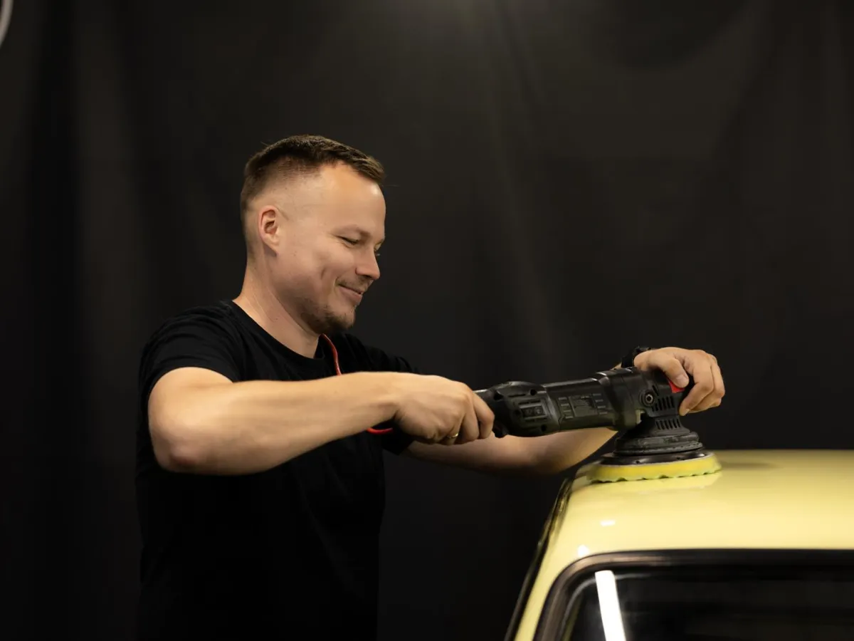 Piotr poleruje lakier auta maszyną polerską w studiu Fabryka Detailingu